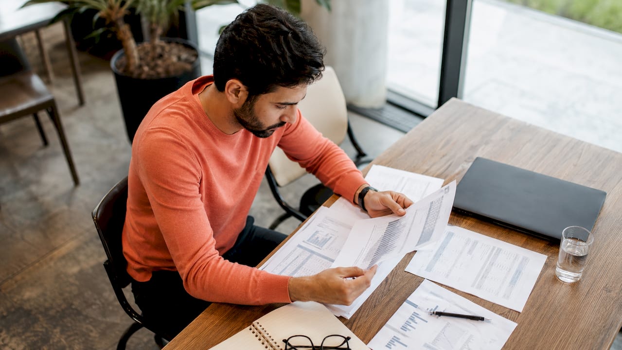 Entrepreneur reviewing ecommerce acquisition documents at home desk
