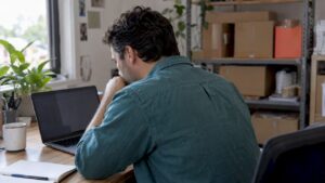 Ecommerce owner reviewing sales on laptop
